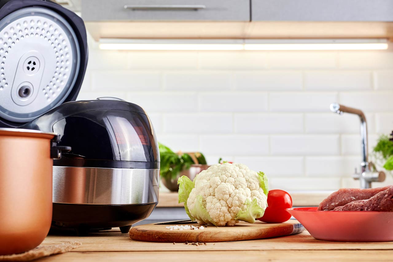 Modern pot with multicooker and products on kitchen table