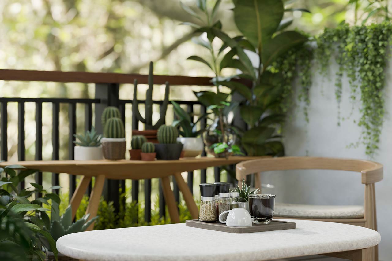 a balcony with various tropical plants, funriture, coffee and a beautiful nature view